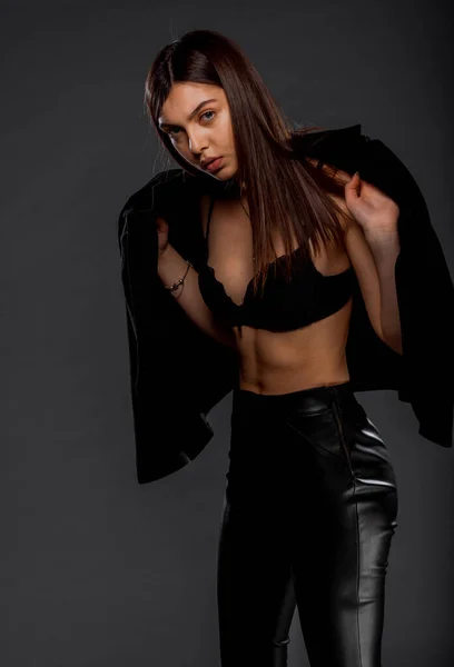 一个穿着黑色夹克和乳胶裤的迷人的时髦女孩的画像 — 图库照片