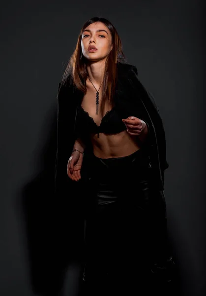 一个穿着黑色皮裤和黑色夹克的漂亮时尚女孩的画像 — 图库照片
