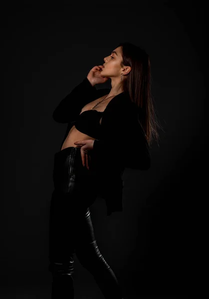 トレンディーなブラックトップとレザーパンツに身を包んだ美しい女性モデルの肖像 — ストック写真