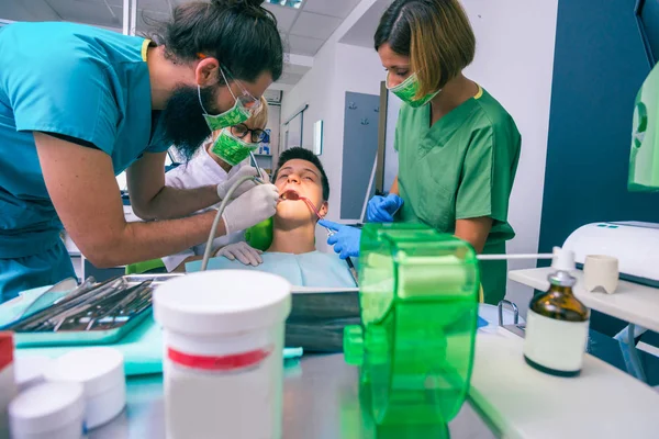 Equipe Dentistas Que Tratam Dentes Seu Jovem Paciente Usando Suas — Fotografia de Stock