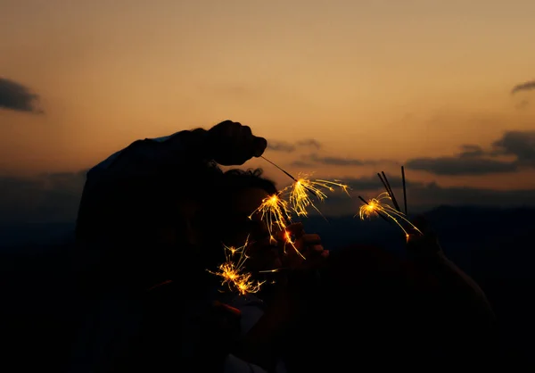 Bengal fire sticks, sparkling, burning, elegant classy ladie and gentlemen hands holding fire-sticks together