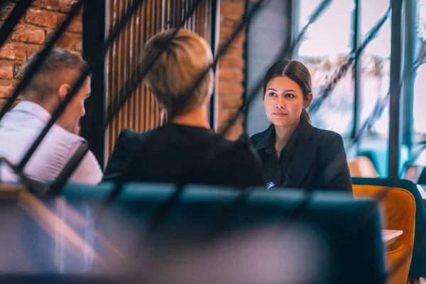 Business meeting inside a cafe with the focus through a fence.