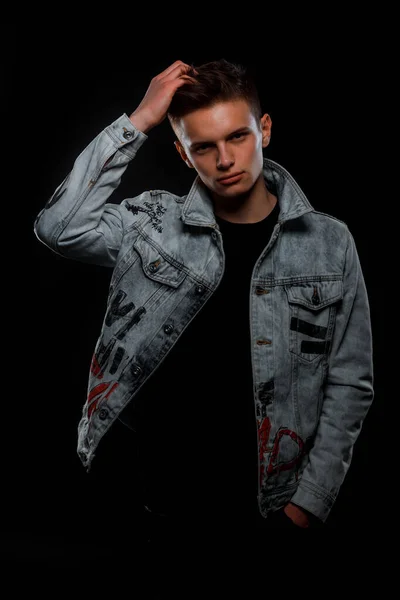 Handsome trendy guy posing in a textil jacket isolated on black background