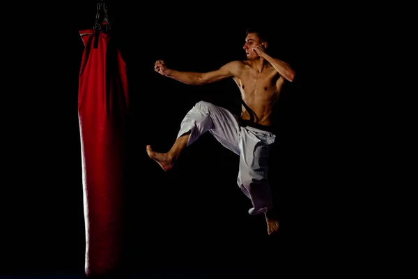 Mann Weißer Kimono Hose Trainiert Karate Kick Einem Boxsack Vor — Stockfoto