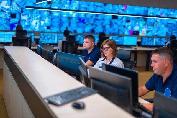 複数のモニター コンピュータ画面 を見ながらCctv監視室でグループで働くセキュリティデータセンター事業者 管理者 のグループ — ストック写真