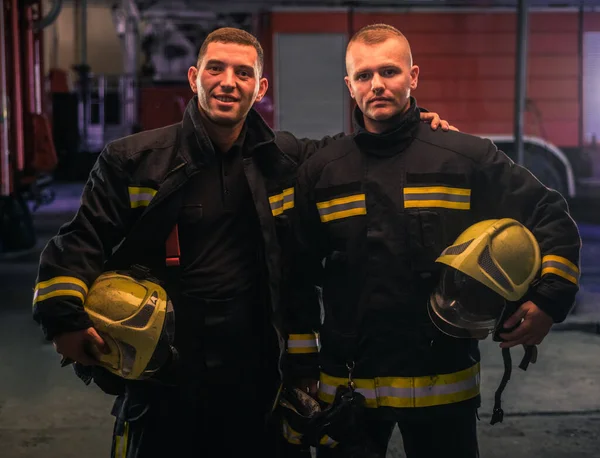 Portret Dwóch Młodych Strażaków Mundurze Stojących Remizie Strażackiej — Zdjęcie stockowe