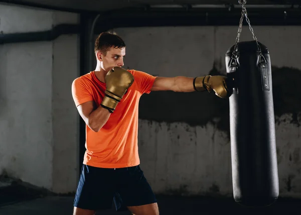 Αθλητικός Άντρας Χτυπάει Μια Τσάντα Γάντια Πυγμαχίας Στο Γυμναστήριο Έννοια — Φωτογραφία Αρχείου