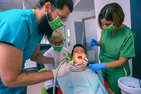 Equipe Dentistas Que Tratam Dentes Seu Jovem Paciente Usando Suas — Fotografia de Stock