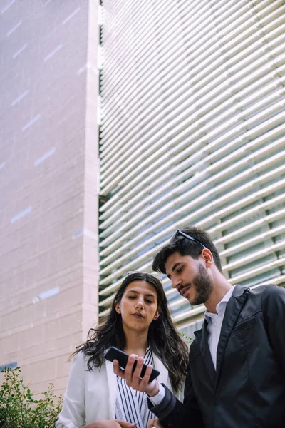 Duas Pessoas Negócios Sentadas Uma Empresa Externa Olhando Celular Com — Fotografia de Stock