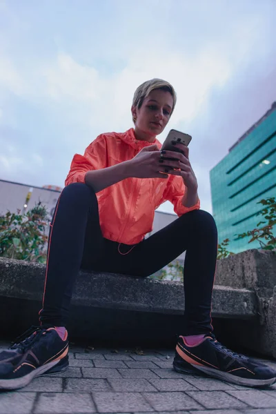 Spor Giyim Kuşağında Beyaz Bir Kadın Akıllı Telefonuna Bakıyor — Stok fotoğraf