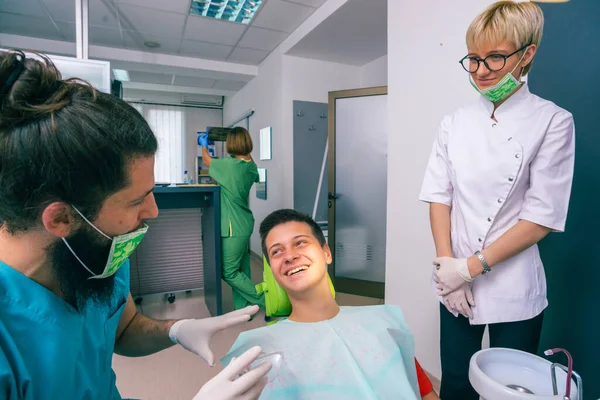 Paciente Adolescente Feliz Está Sorrindo Para Seus Dentistas Enquanto Eles — Fotografia de Stock