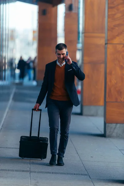 Jovem Empresário Caminhando Através Uma Estação Enquanto Fala Telefone Puxando — Fotografia de Stock