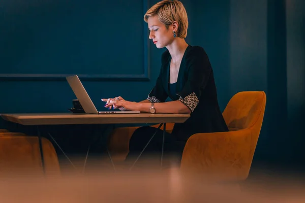 Pewna Siebie Młoda Bizneswoman Pracująca Laptopie Siedząc Rogu Kawiarni Ciemnoniebieskimi — Zdjęcie stockowe