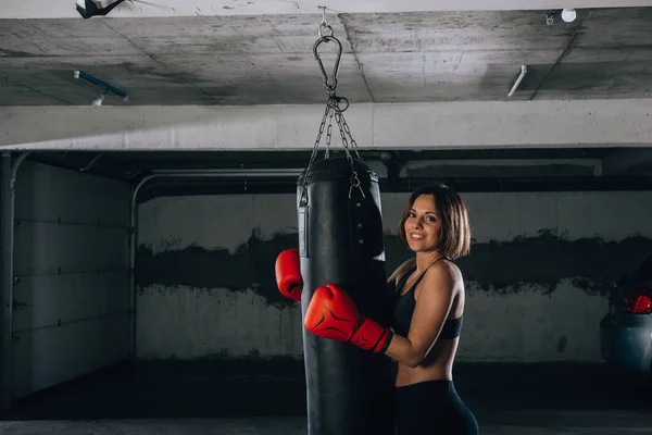 Imagen Una Joven Sonriente Fuerte Sosteniendo Una Bolsa Boxeo Dentro — Foto de Stock