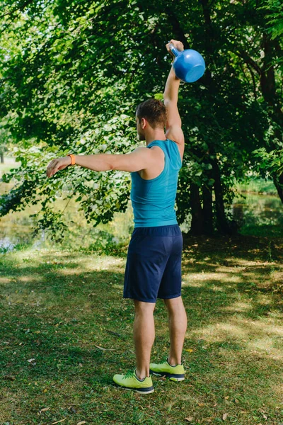 公園でケトルベル スイング運動を行うフィットネス男 — ストック写真