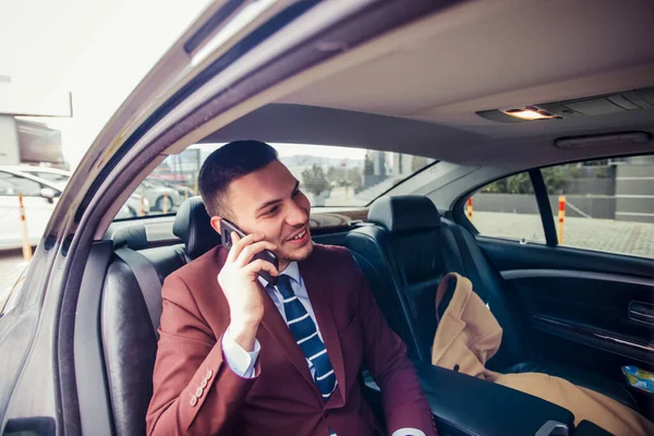 Empresário Bonito Está Dirigindo Uma Limusina Enquanto Fala Telefone Celular — Fotografia de Stock