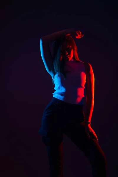 コントラストの高い黒の背景に女性モデルの青と赤の光の肖像画 — ストック写真