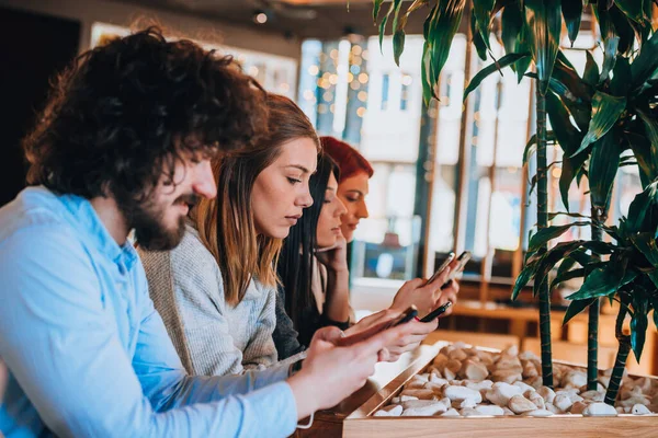 Jóvenes Con Estilo Restaurante Cafetería Mirando Sus Teléfonos Móviles —  Fotos de Stock