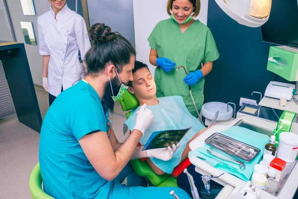 Dentistas Masculinos Femininos Mostrando Jovem Paciente Com Seus Dentes Imagem — Fotografia de Stock