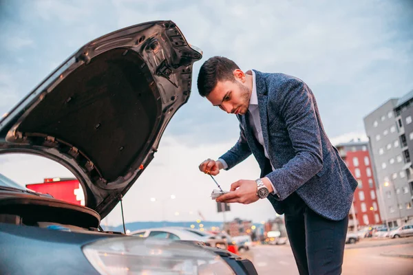 Joven Gerente Vestido Formalmente Comprobando Aceite Coche Atardecer Mientras Inclina — Foto de Stock