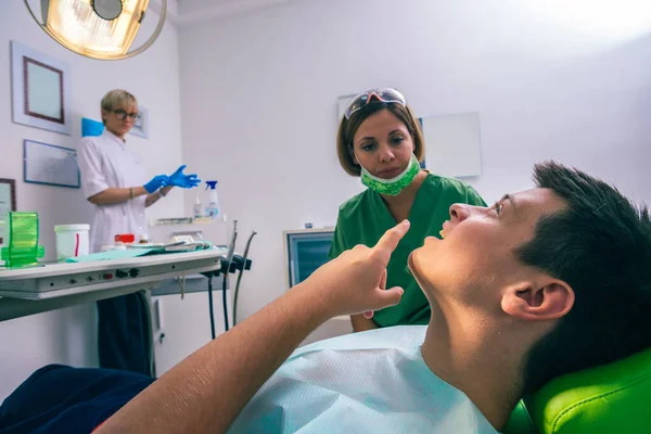 Zbliżenie Nastoletniego Pacjenta Pokazującego Ból Zęba Swojej Dentystce Gabinecie Dentystycznym — Zdjęcie stockowe
