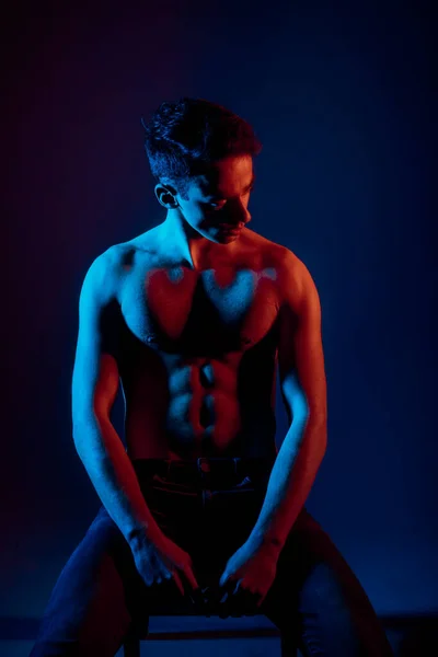 Muscles young shirtless man posing in black denim jeans. Dual tone