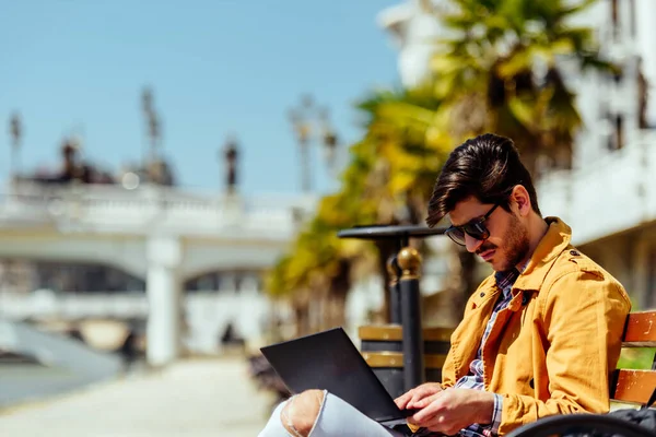 Modischer Geschäftsmann Arbeitet Auf Laptop Während Auf Einer Bank Sitzt — Stockfoto