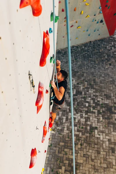 Człowiek Wspinaczka Sztucznej Ścianie Wspinaczkowej Siłowni Bouldering — Zdjęcie stockowe