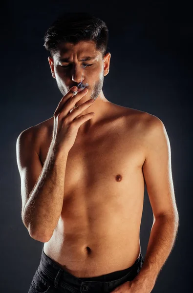 Hombre Atractivo Posando Sin Camisa Vaqueros Negros Rasgados Fumando —  Fotos de Stock