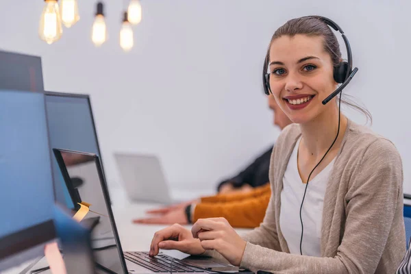 Aantrekkelijke Zakenvrouw Met Een Headset Werkend Een Laptop Een Moderne — Stockfoto