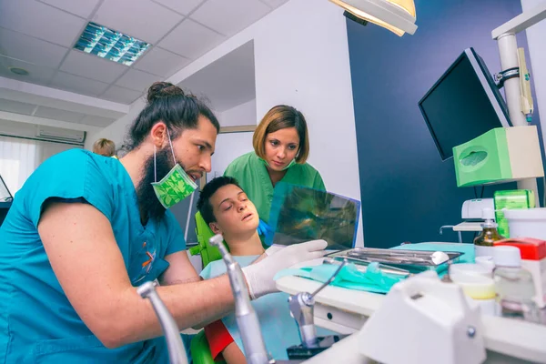 Dentistas Masculinos Femininos Mostrando Jovem Paciente Com Seus Dentes Imagem — Fotografia de Stock