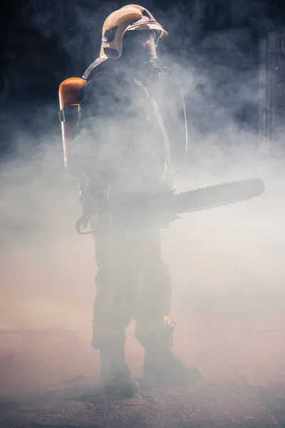 Portrait Young Fireman Standing Holding Chainsaw Middle Chainsaw Smoke — Stock Photo, Image