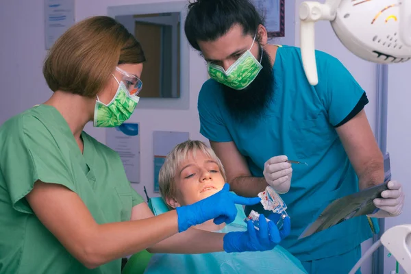 歯と顎のX線写真を患者に見せる若い女性と男性の歯科医 — ストック写真