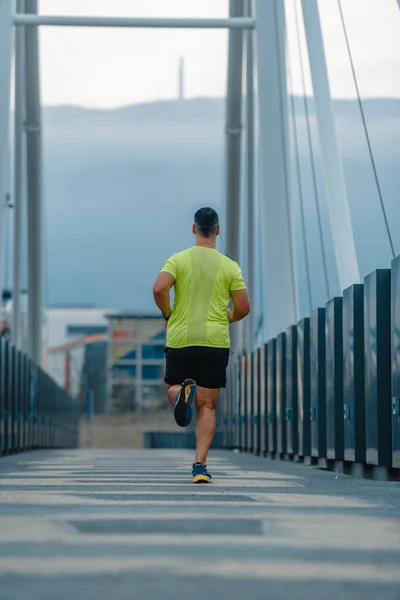 Well built man over 40 wearing activewear training gear running