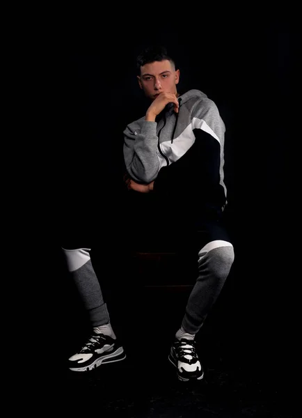 Atraente Jovem Masculino Modelo Posando Tracksuit Enquanto Sentado Cheir — Fotografia de Stock