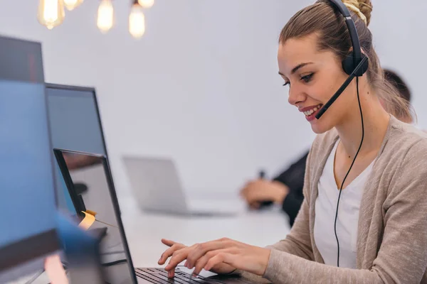 Aantrekkelijke Zakenvrouw Met Een Headset Werkend Een Laptop Een Moderne — Stockfoto