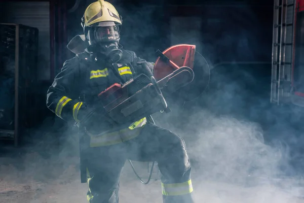 Портрет Пожарного Полном Защитном Снаряжении Позирующего Бензопилой Плече Темный Фон — стоковое фото