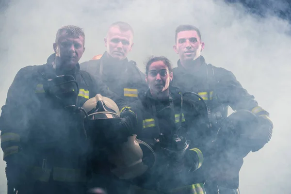 消防署内で消火器の煙の真ん中に立つ消防団 — ストック写真