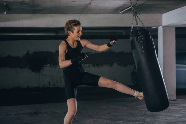 Mulher Branca Sportswear Com Ligaduras Pretas Chutando Saco Boxe Dentro — Fotografia de Stock