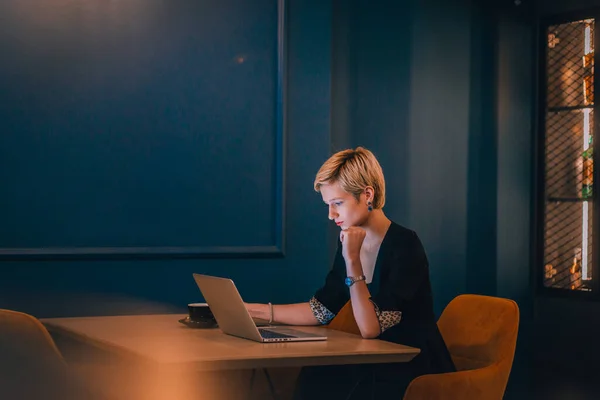 Pewna Siebie Młoda Bizneswoman Pracująca Laptopie Siedząc Rogu Kawiarni Ciemnoniebieskimi — Zdjęcie stockowe
