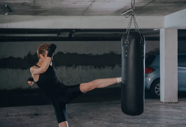 Mujer Caucásica Ropa Deportiva Con Vendajes Negros Pateando Bolsa Boxeo — Foto de Stock