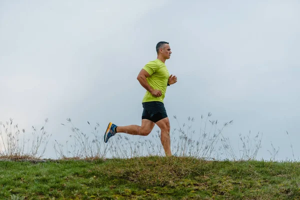 Well built man over 40 wearing activewear training gear running