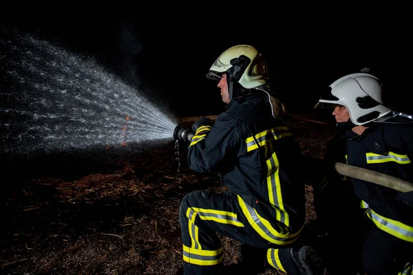 Bomberos Con Uniforme Protector Apagando Fuego Ardiente —  Fotos de Stock