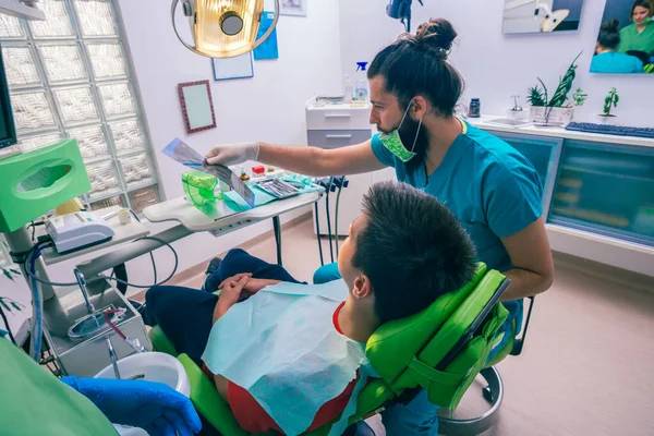 Adolescente Sentado Como Paciente Uma Cadeira Dentista Dentista Masculino Preparando — Fotografia de Stock