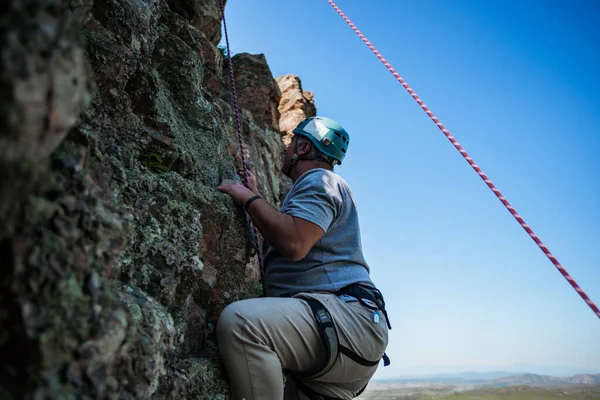 年轻的男性攀岩者在富有挑战性的路线上紧紧抓住小手 — 图库照片