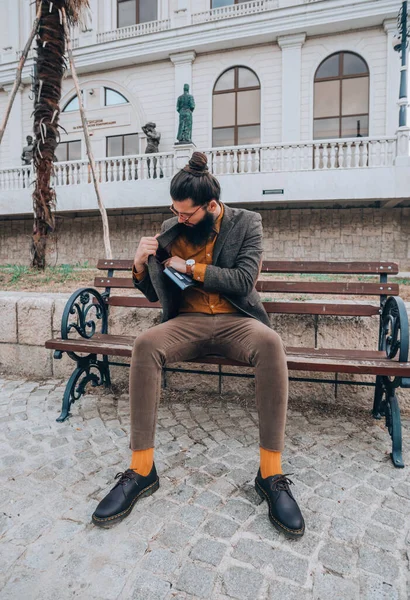 Νέος Όμορφος Hipster Άντρας Κάθεται Ένα Ξύλινο Παγκάκι Στην Πόλη — Φωτογραφία Αρχείου