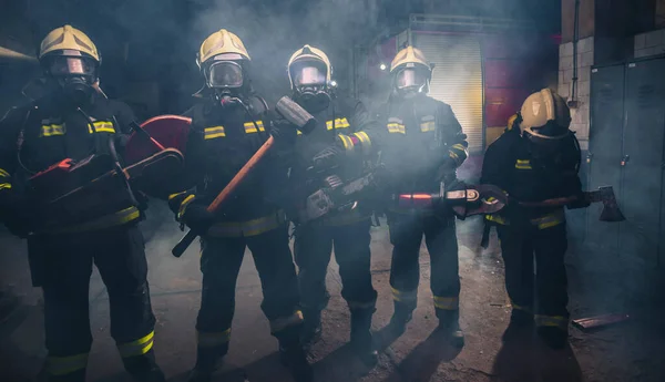 Grupa Strażaków Piłą Łańcuchową Młotkiem Kowalskim Ćwiczących Garażu Straży Pożarnej — Zdjęcie stockowe