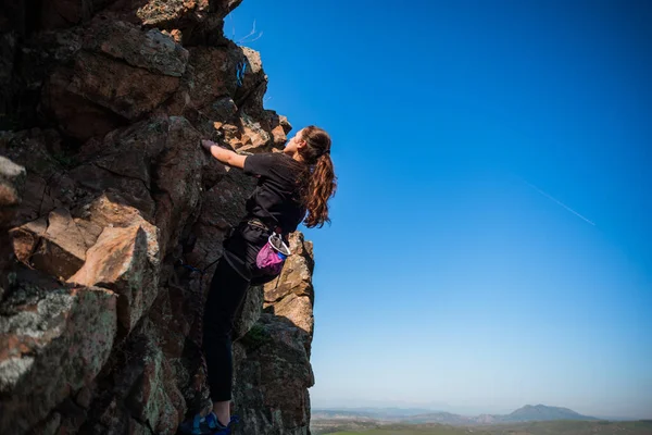 石の岩の上に登る安全装置の美しい女の子 — ストック写真