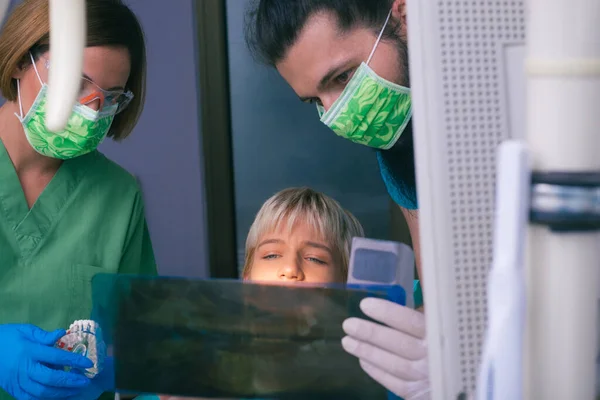 Odontólogos Femeninos Masculinos Jóvenes Mostrando Paciente Una Radiografía Sus Dientes —  Fotos de Stock