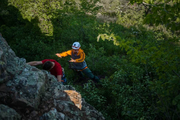 強い男は友人の助けを借りて山に登る — ストック写真